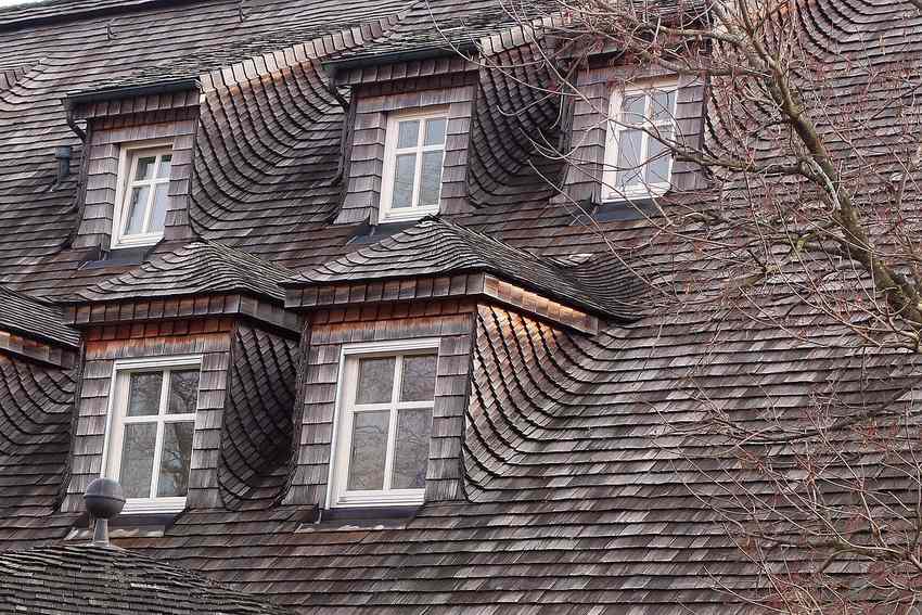 Toiture en ardoises avec trois lucarnes et fenêtres blanches