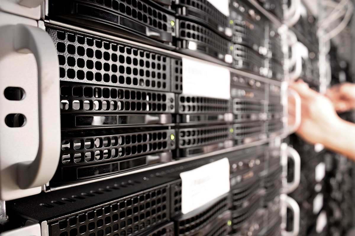 Baie de serveurs informatiques noirs en rack avec technicien intervenant sur équipements