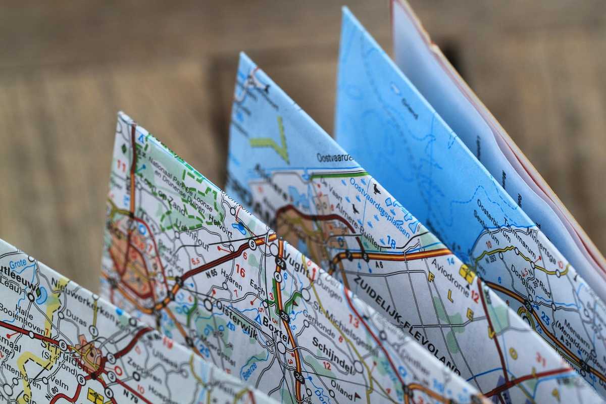 Cartes routières pliées sur une surface en bois Cartes routières pliées sur une surface en bois